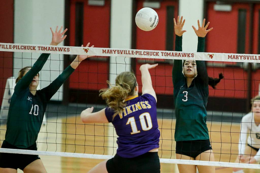 Jacksons Lauren Demoulin (left) and Ciarra Choe (right) go up for a block against Lake Stevens Anna Saack during the 4A District 1 championship match on Thursday at Marysville Pilchuck High School. (Ian Terry / The Herald)