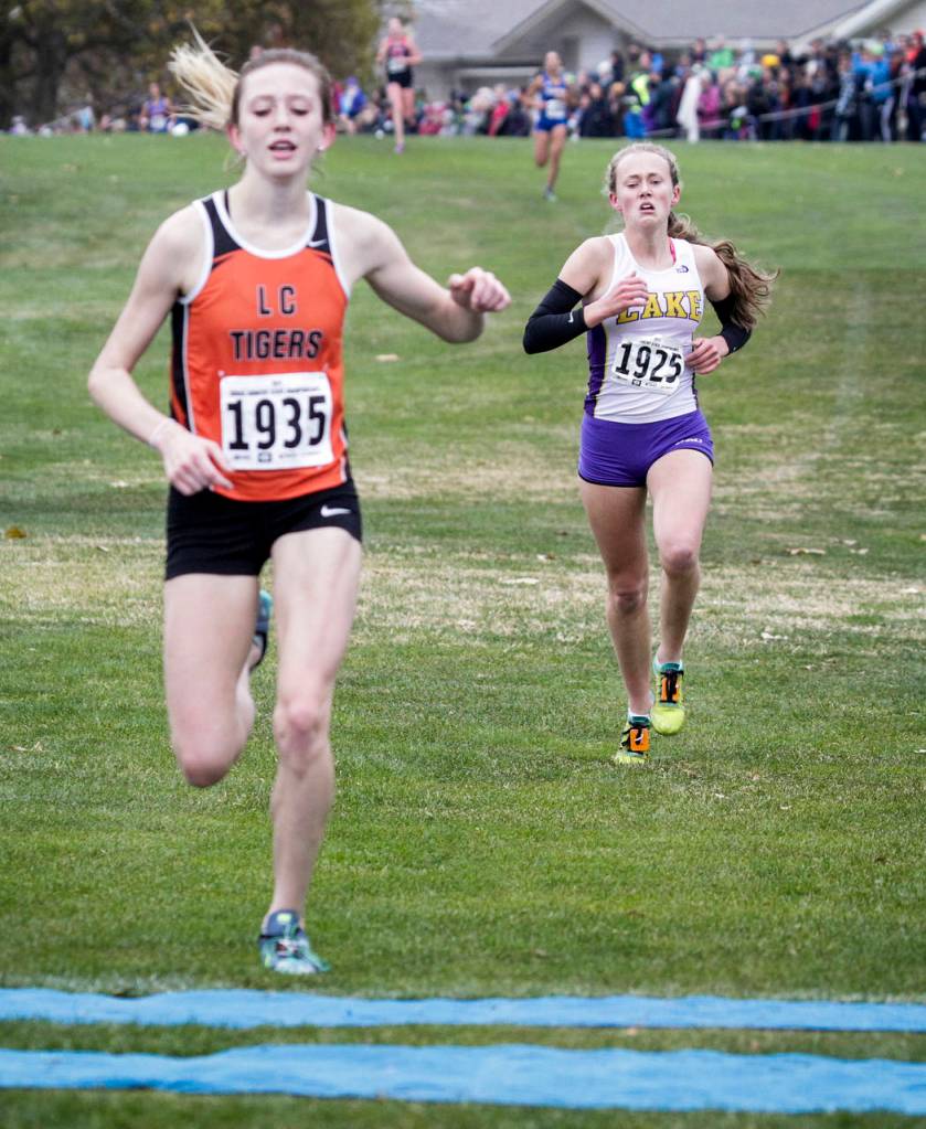 Lake Stevens Taylor Roe (right) finishes in second place close behind Lewis and Clarks Katie Thronson during the girls 4A state cross country championships on Nov. 4, 2017, at Sun Willows Golf Course in Pasco. (Ian Terry / The Herald)