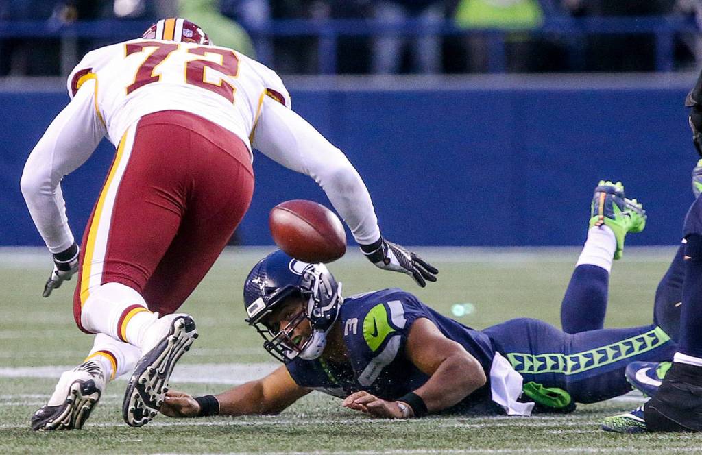 Seahawks quarterback Russell Wilson is shoe string sacked by Redskins Terrell McClain (not pictured) as Redskins Anthony Lanier III closes Sunday afternoon at CenturyLink Field in Seattle on November 5, 2017. Redskins won 17-14. (Kevin Clark / The Herald)