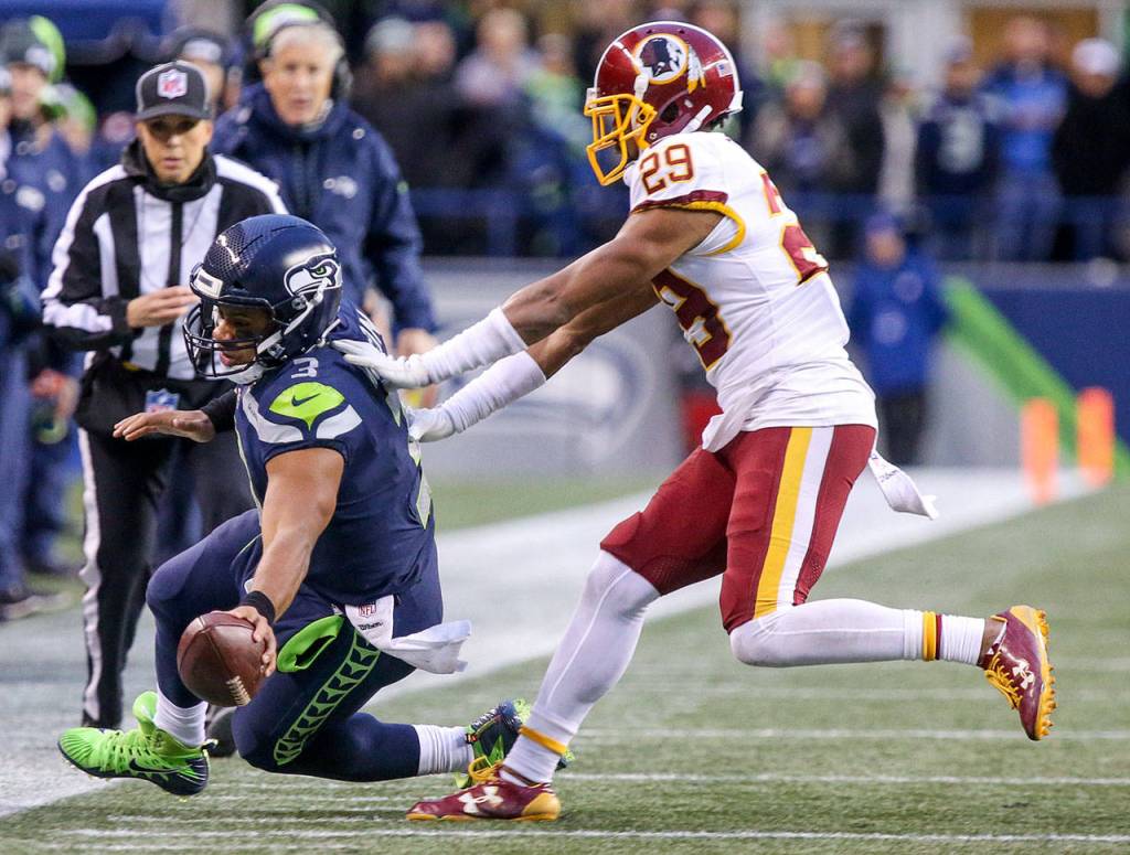 Seahawks quarterback Russell Wilson reaches for a first down as Redskins Kendall Fuller pushes him out of bounds Sunday afternoon at CenturyLink Field in Seattle on November 5, 2017. Redskins won 17-14. (Kevin Clark / The Herald)