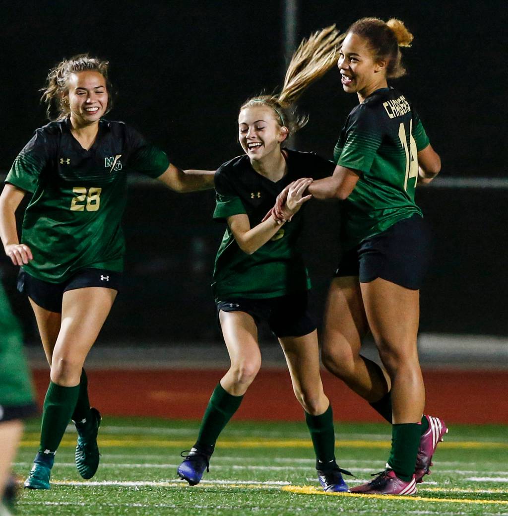 Marysville-Getchells Oshinaye Taylor (right) celebrates her goal with teammates Jadin Thompson-Sheldon (center) and Alivia Doll (left) during a game against Shorecrest at Edmonds Stadium on Oct. 31. (Ian Terry / The Herald)