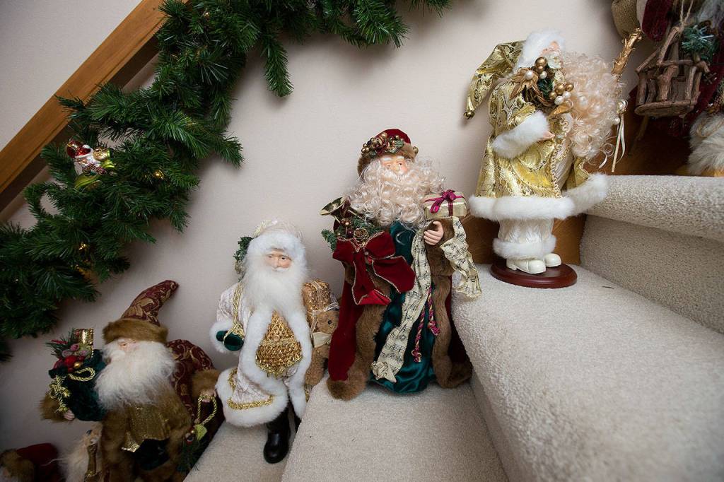 Sally and Tom Joy have decorated a stairway with Santa Claus dolls on each step leading to the basement. (Andy Bronson / The Herald)