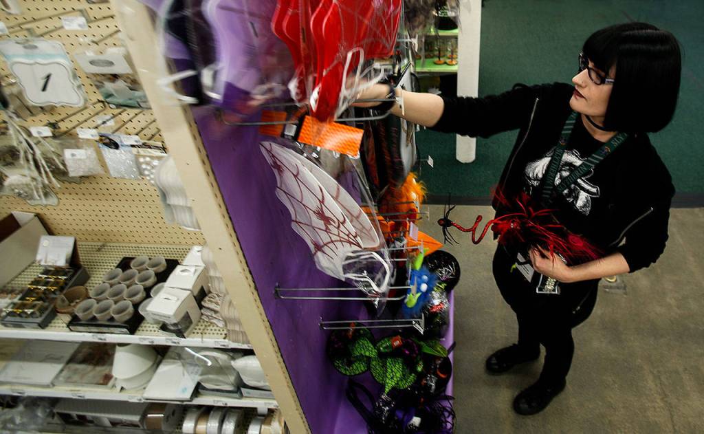 At Everett Display & Costume Monday, floor manager Christine Crosbie straightens and organizes discounted merchandise. (Dan Bates / The Herald)