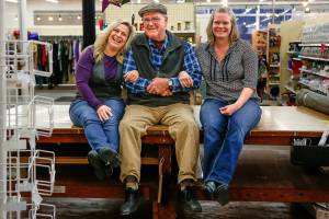 In Everett Monday, Display & Costume co-owner Dallas Carleton is joined on the stores big fabric-cutting table by his niece and manager of the Evertt store, Angie Durham (left) and his daughter Margaret McGowan (right). McGowan is the corporate manager of all the Display & Costume stores. The company is closing its Everett store. They will continue operation of their large store near Northgate in Seattle as well as their Issaquah store. (Dan Bates / The Herald)