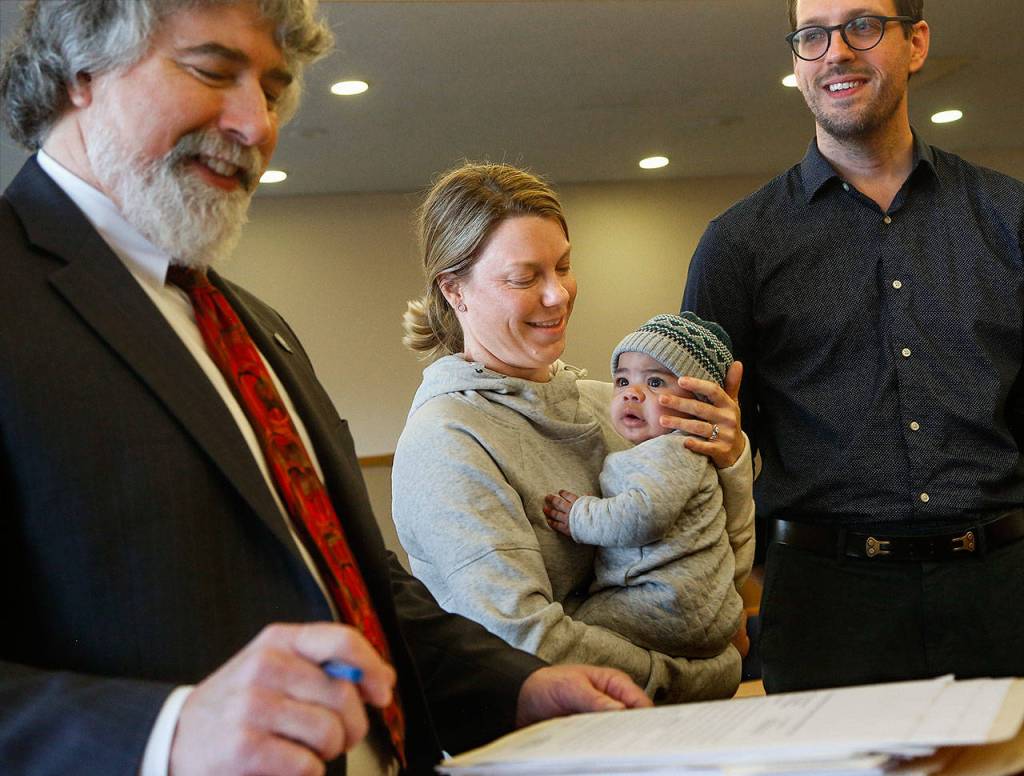 Five-month-old Felix gazes at Edmonds attorney Mark Demaray, as the lawyer guides Josh and Alicia Shope through adoption proceedings for the child before Snohomish County Superior Court Judge David Kurtz on Friday. (Dan Bates / The Herald)