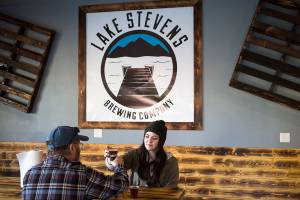 Julia Turner and her father, Ed, toast as they try out a flight of beer and cider at Lake Stevens Brewing Co. when it opened last year. (Andy Bronson / The Herald)