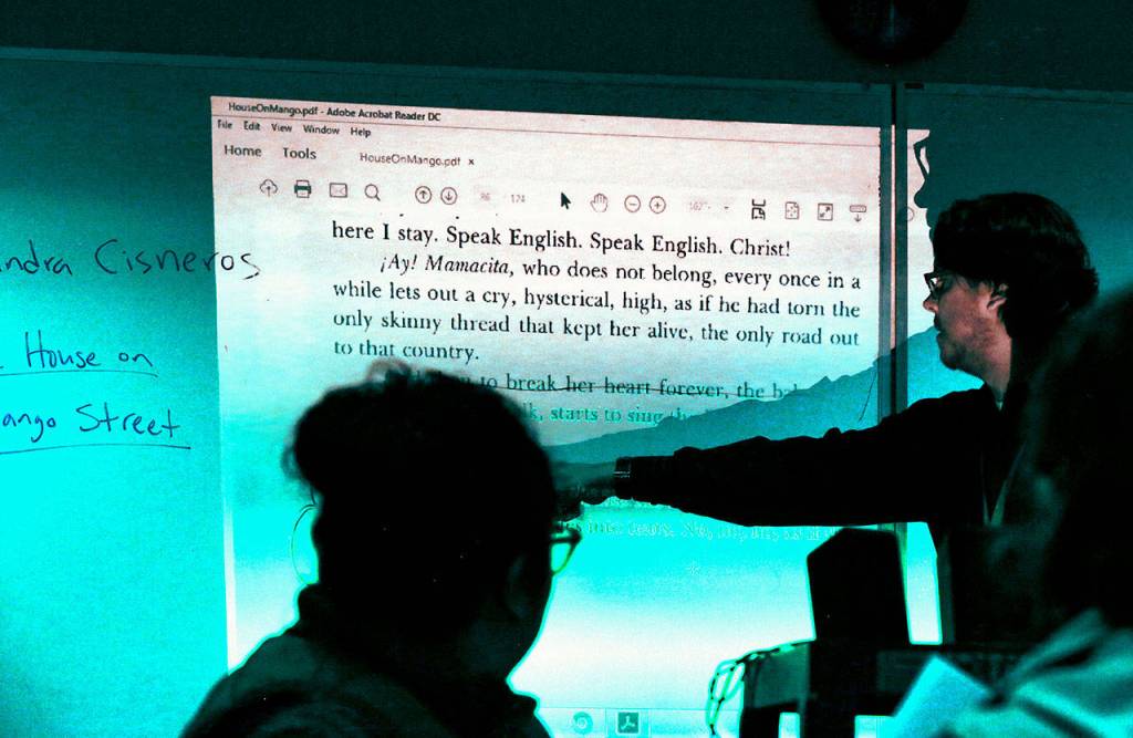 Jacob Nanfito, an instructor with Goodwill Industries, teaches a large ESOL class to moms Tuesday while in another room at the same Casino Road Community Center, instructors with the YMCA are teaching their 5-and-under pre-school kids. (Dan Bates / The Herald)
