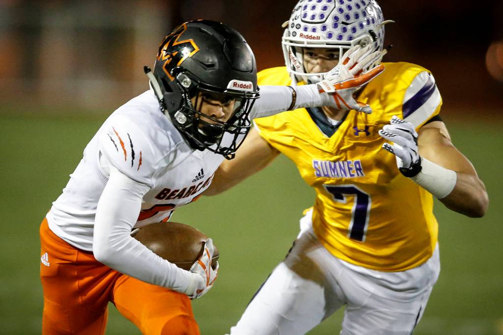 Monroes Trey Lane (left) runs past Sumner defender Tre Weed during a Class 4A state football quarterfinal game at Sunset Chev Stadium in Sumner on Saturday, Nov. 18. (Ian Terry / The Herald)