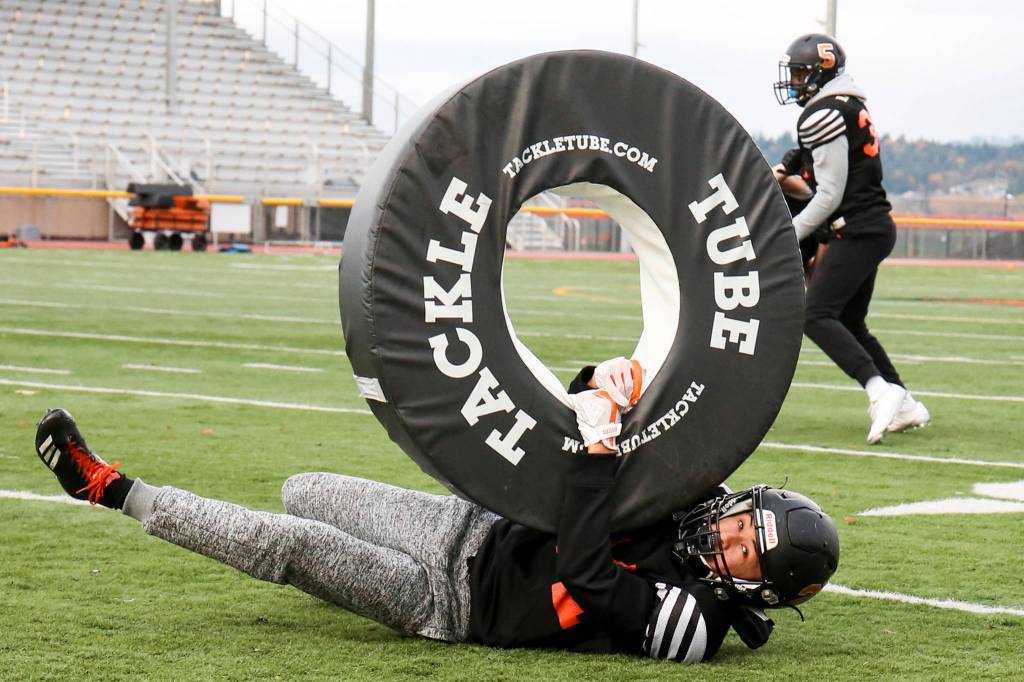 Trey Lane tackles in drills during practice at Monroe High School on Nov. 15. (Kevin Clark / The Herald)
