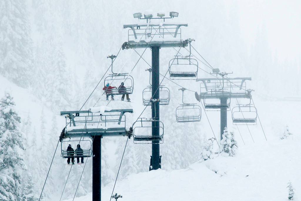 Skiers and snowboarders make their way up the Skyline Express chairlift at Stevens Pass on Nov. 16. (Ian Terry / The Herald)