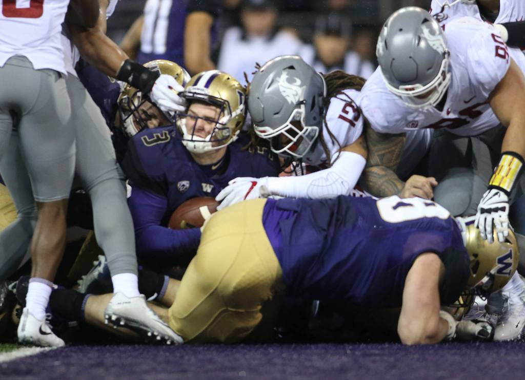 Washington Huskies quarterback Jake Browning (3) has his facemark pulled as he goes in for a touchdown as the Washington State Cougars lost to the Washington Huskies 41-14 at Husky Stadium in the 110th Apple Cup on Saturday, Nov. 25, 2017 in Seattle, Wa. (Andy Bronson / The Herald)