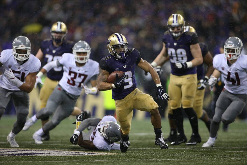 Washington Huskies running back Myles Gaskin (9) escapes a tackle, runs then dives in for a touchdown as the Washington State Cougars lost to the Washington Huskies 41-14 at Husky Stadium in the 110th Apple Cup on Saturday, Nov. 25, 2017 in Seattle, Wa. (Andy Bronson / The Herald)