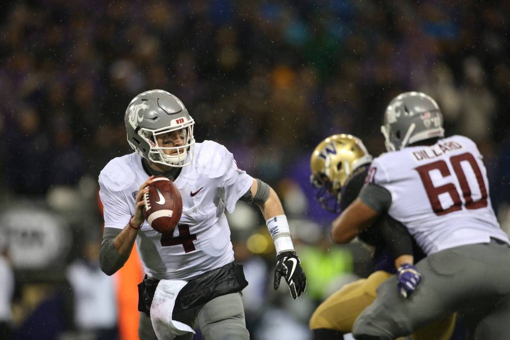 Washington State Cougars quarterback Luke Falk (4) is chased out of the pocket as the Washington State Cougars lost to the Washington Huskies 41-14 at Husky Stadium in the 110th Apple Cup on Saturday, Nov. 25, 2017 in Seattle, Wa. (Andy Bronson / The Herald)
