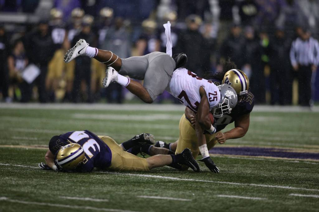 Washington State Cougars running back Jamal Morrow (25) is upended as he gains a few yards as the Washington State Cougars lost to the Washington Huskies 41-14 at Husky Stadium in the 110th Apple Cup on Saturday, Nov. 25, 2017 in Seattle, Wa. (Andy Bronson / The Herald)