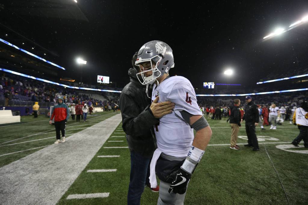 Former WSU quarterback Drew Bledsoe pats quarterback Luke Falk (4) after the Washington State Cougars lost to the Washington Huskies 41-14 at Husky Stadium in the 110th Apple Cup on Saturday, Nov. 25, 2017 in Seattle, Wa. (Andy Bronson / The Herald)