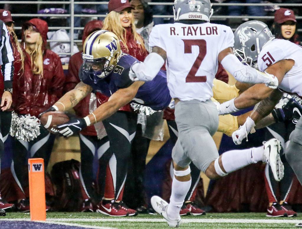 Washington Huskies running back Myles Gaskin dives for the pylon and a touchdown in the third quarter Saturday night during the 110th Apple Cup at Husky Stadium in Seattle November 25, 2017. Washington won 41-14. (Kevin Clark / The Herald)