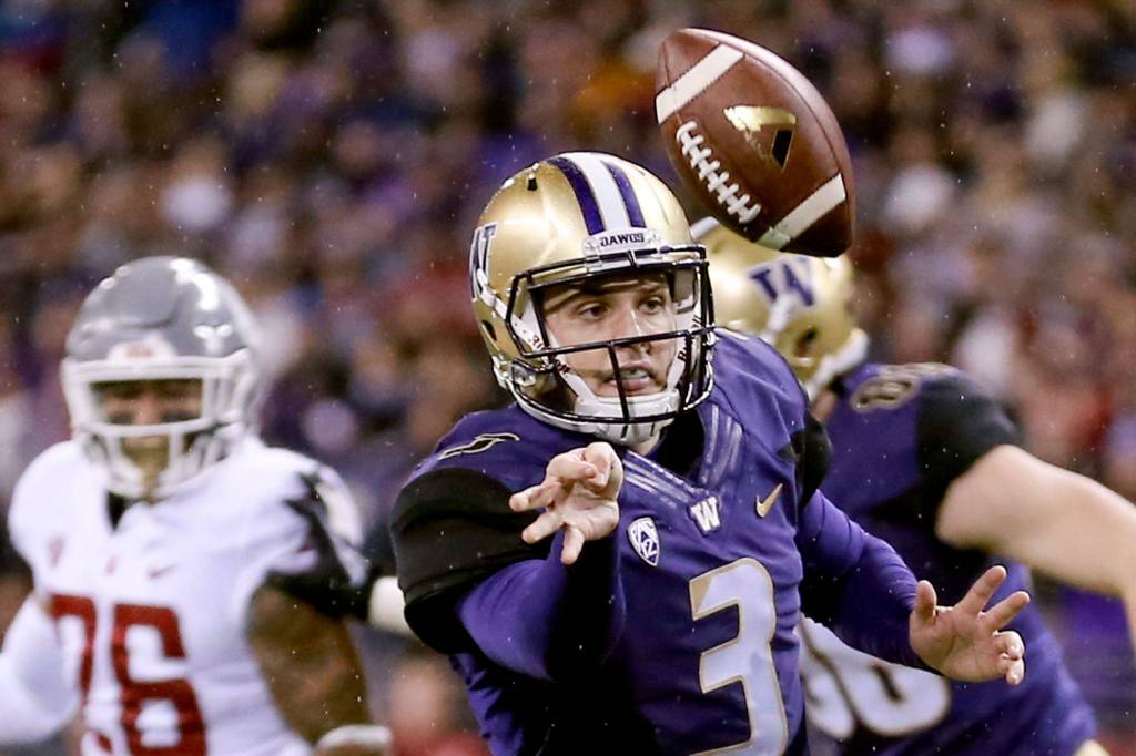 Washington Huskies quarterback Jake Browning flicks the ball off a scramble Saturday night during the 110th Apple Cup at Husky Stadium in Seattle November 25, 2017. Washington won 41-14. (Kevin Clark / The Herald)