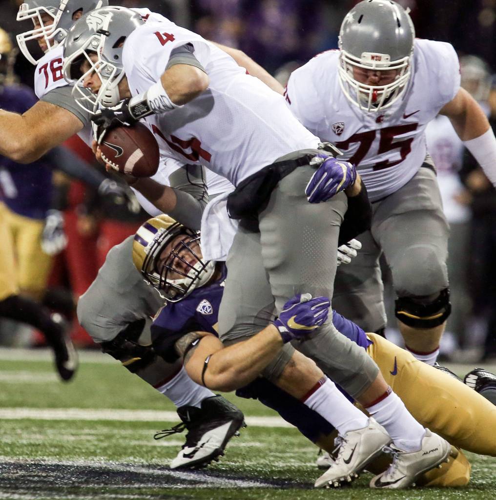 Washington Huskies linebacker Ryan Bowman sacks Washington State Cougars quarterback Luke Falk Saturday night during the 110th Apple Cup at Husky Stadium in Seattle November 25, 2017. Washington won 41-14. (Kevin Clark / The Herald)