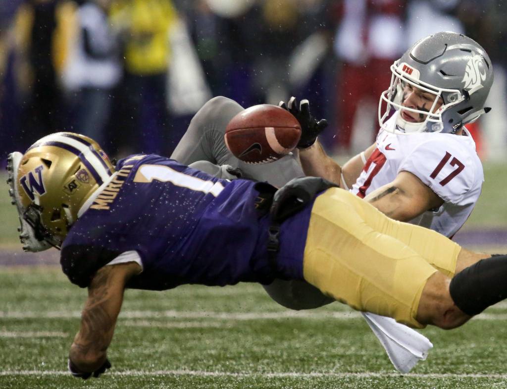 Washington Huskies defensive back Byron Murphy tackles Washington State Cougars wide receiver Kyle Sweet and forces a fumble Saturday night during the 110th Apple Cup at Husky Stadium in Seattle November 25, 2017. Washington won 41-14. (Kevin Clark / The Herald)