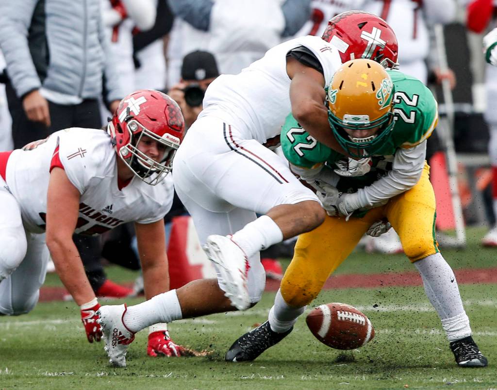 Tumwaters Jakob Holbrook (22) fumbles after being hit by Archbishop Murphys Kyler Gordon during a Class 2A semifinal state football game on Nov. 25, 2017, at Sparks Stadium in Puyallup. (Ian Terry / The Herald)