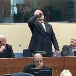 Slobodan Praljak brings a bottle to his lips during a Yugoslav War Crimes Tribunal in The Hague, Netherlands, seconds after judges reconfirmed his 20-year prison sentence. (ICTY via AP)