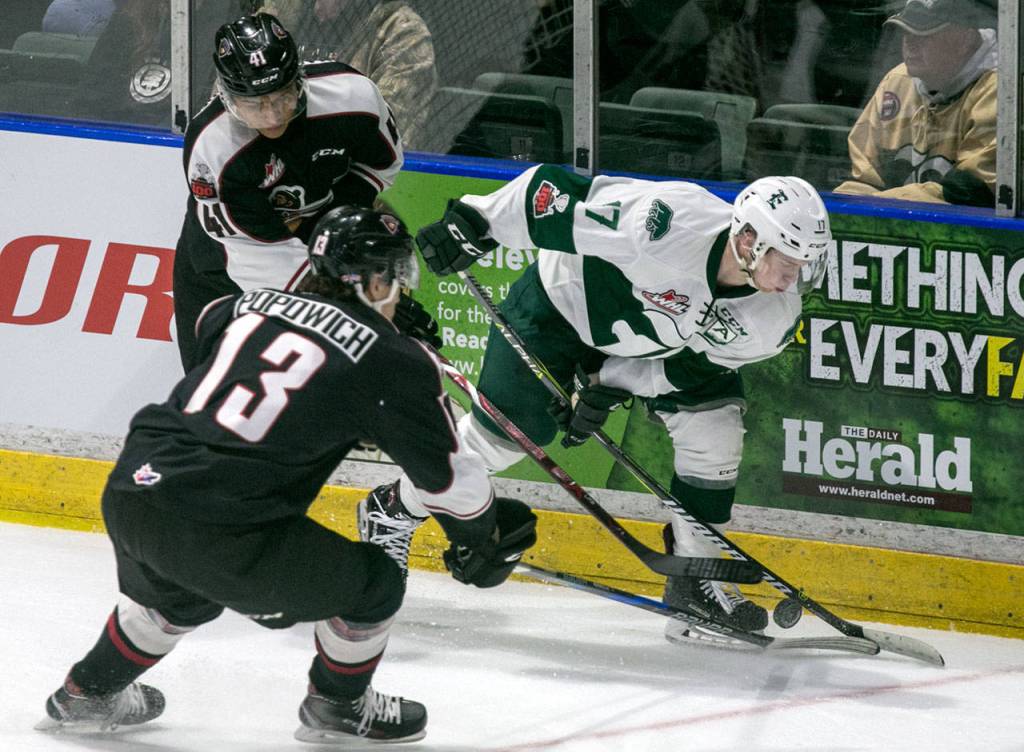 The Silvertips Matt Fonteyne (right) controls the puck with Vancouvers Alex Kannok Leipert (left) and Tyler Popowich giving chase in the first period of a game Dec. 29, 2017, at Angel of the Winds Arena in Everett. (Kevin Clark / The Herald)