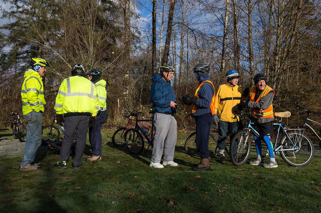 Bert Larsson, 91 (right), joins the group at Lake Cassidy after biking from Snohomish via the Centennial Trail on Dec. 4 in Arlington. (Andy Bronson / The Herald)