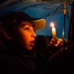 Ryder Ransom, 11, holds up his candle while singing Chanukah songs at a celebration for the Festival of Lights during the fifth annual public Menorah Lighting Ceremony at the Lynwood City Hall on Dec. 26 of last year. Nearly 50 gathered to sing, eat and celebrate the third night of Chanukah. (Daniella Beccaria / Herald file)