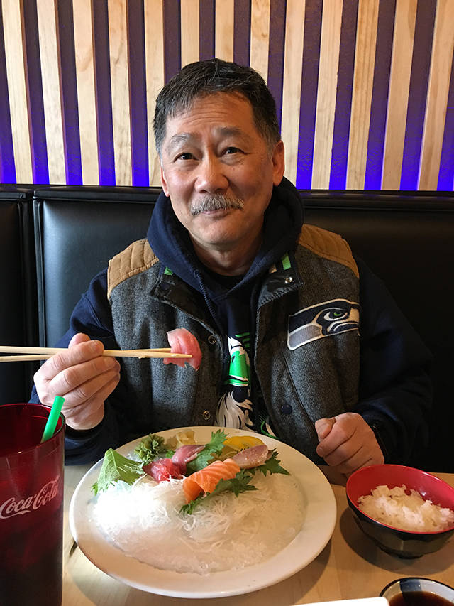 Glen Watanabe, of Lake Stevens, tries a piece of tuna sashimi at Kai Sushi in Everett. (Ben Watanabe / The Herald)