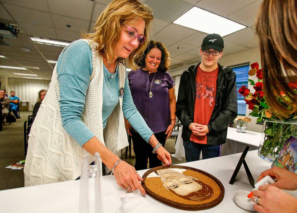 Parker Langs mom, Vicki Moore (left), will share finishing the work on Parkers floragraph with a few people including Parkers kidney recipient Mary Monteleone Raben (center) and Parkers best friend, Logan McGill, before it goes on to Pasadena. (Dan Bates / The Herald)
