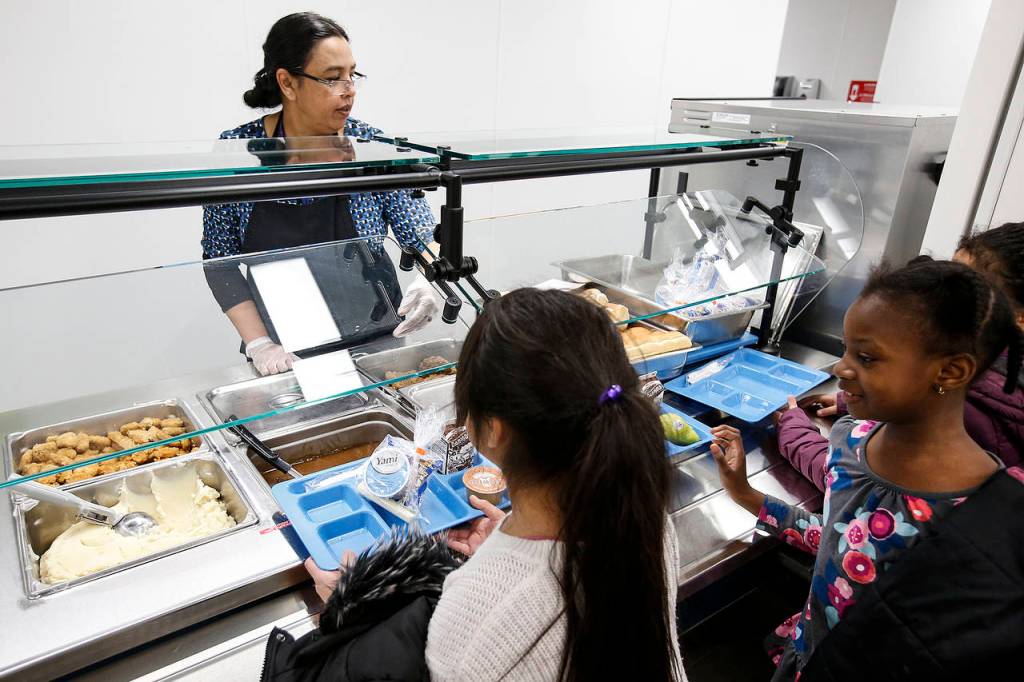 Humaira Sheikh (left) serves students during lunchtime at Lynndale Elementary School in Lynnwood on Thursday, Nov. 30. (Ian Terry / The Herald)