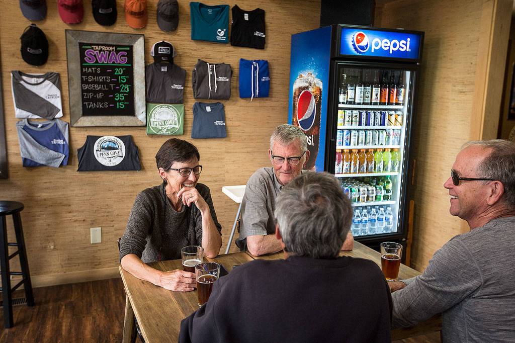 Friends (from left) Carla Corin, Joe Hillers, Jim Somers and Lenny Corin enjoy a beer at Penn Cove Brewing Company in Coupeville on July 7. (Ian Terry / Herald file)