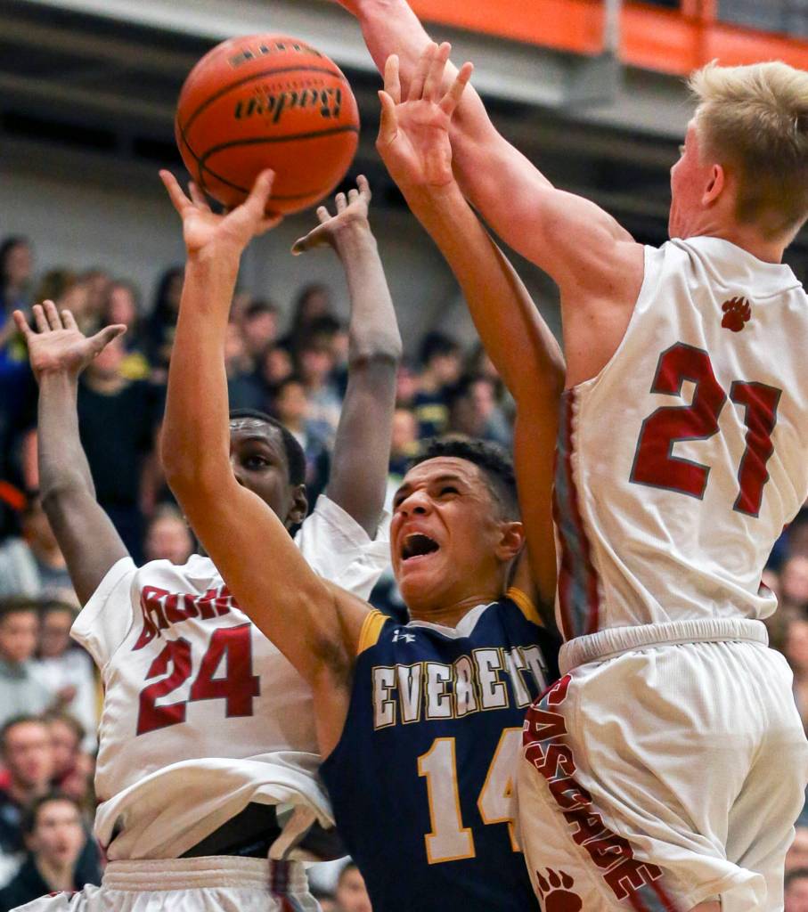 Everetts Elijah Ross-Rutter attempts to shoot through Cascades Musa Baldeh (left) and Cascades Nicholas Klemp at Everett Community College on Dec. 1. (Kevin Clark / The Herald)