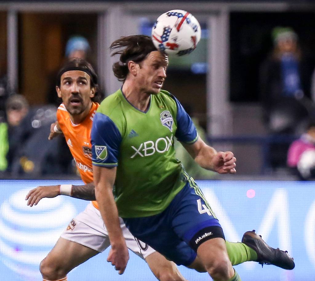 Seattles Gustav Svensson heads the ball with Houstons Vicente Sanchez trailing in the first half of the Western Conference Finals at CenturyLink Field in Seattle on Nov. 30. (Kevin Clark / The Herald)