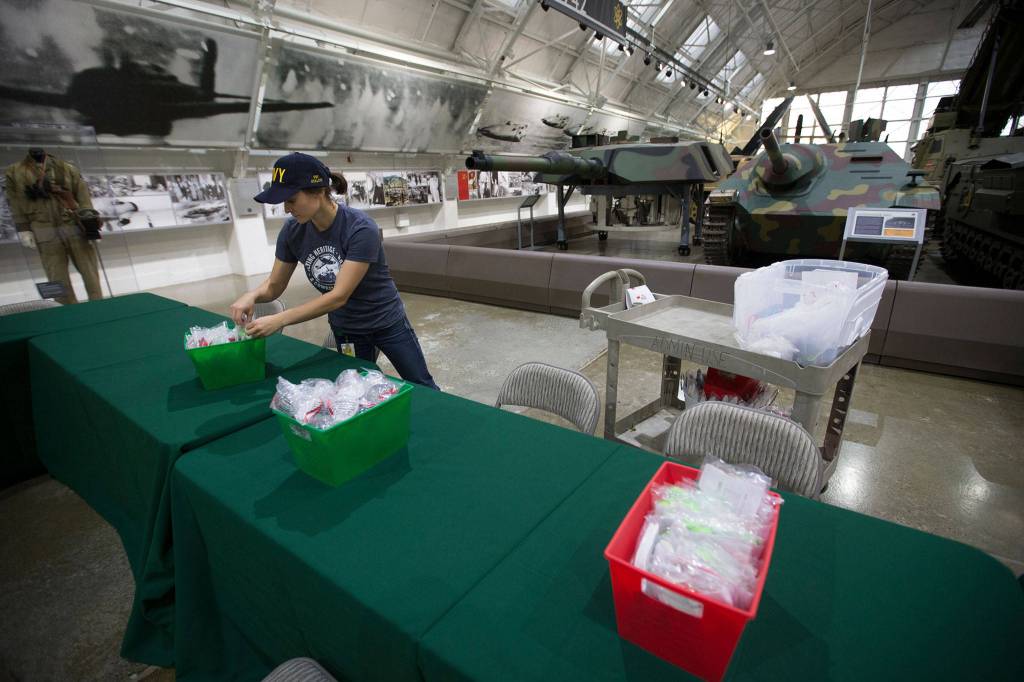 Marketing & Events Coordinator Michelle Donoghue sets up games and activities for Saturdays 2nd Annual Tanks Giving event at the Flying Heritage & Combat Armor Museum on Dec. 1. in Everett. (Andy Bronson / The Herald)