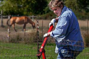 Ann Phelps, a United Way Day of Caring volunteer in 2015, repairs fences at the All Breed Equine Rez-Q. The land, located along 116th St. NE in Marysville, has been a haven for abused and unwanted horses, but the lease is not being renewed. (Dan Bates / The Herald)
