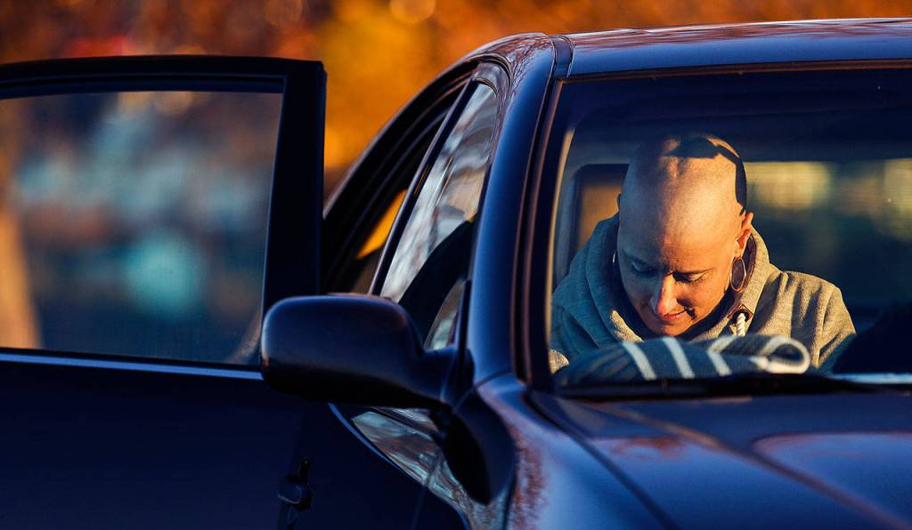 Heather Lopez gets into a car to be out of the wind at Mukilteo beach. She changed into a holiday sweater and a different stocking cap. Heather had a brain tumor removed recently, and more have come. (Dan Bates / The Herald)