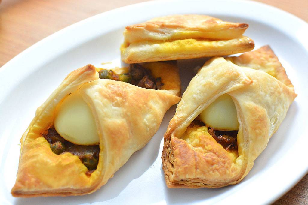 Spicy egg puffs can be made vegetarian by skipping the hard boiled eggs and the egg wash. Just seal in the eggless filling and bake. (Reshma Seetharam)
