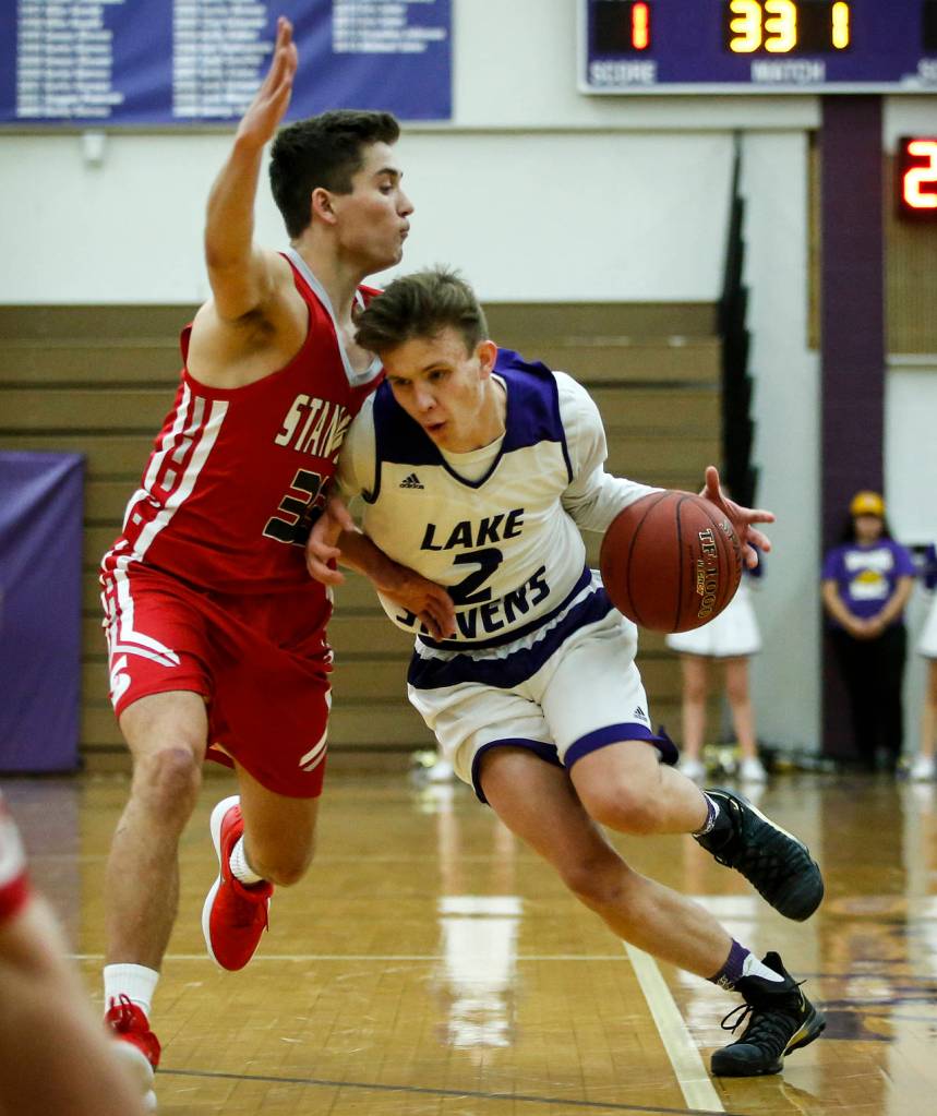 Lake Stevens Ryder Kavanagh (right) drives past Stanwoods Nate Kummer during a game Dec. 5, 2017, at Lake Stevens High School. (Ian Terry / The Herald)