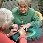 Aleph Swanson (left) and Pearl Hebert glue ruffled netting to a candy wreath. (Melissa Slager / The Daily Herald)