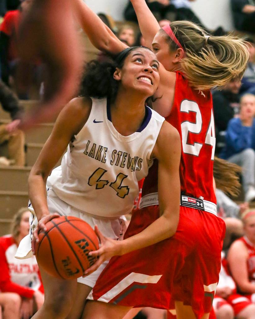 Lake Stevens Kylee Griffen looks to score with Stanwoods Jillian Heichel defending at Lake Stevens High in Lake Stevens on Dec. 6. The Vikings won 56-45. (Kevin Clark / The Herald)
