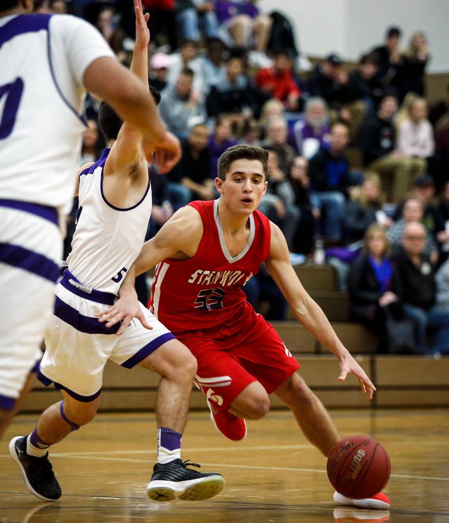 Stanwoods Nate Kummer (right) drives past Lake Stevens Jesse King during a game at Lake Stevens High School on Dec. 5. (Ian Terry / The Herald)