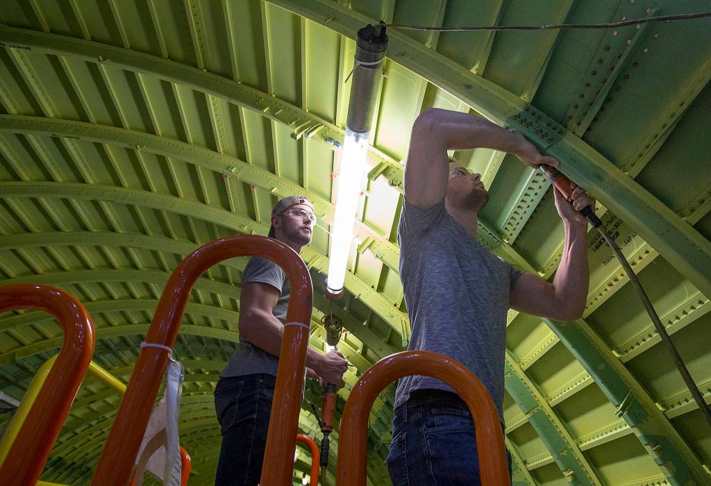 21-year-olds identical twins Erik (right) and Aaron Bannister fasten together sections of a 777 midsection at the Boeing Co. Dec. 4 in Everett. (Andy Bronson / The Herald)