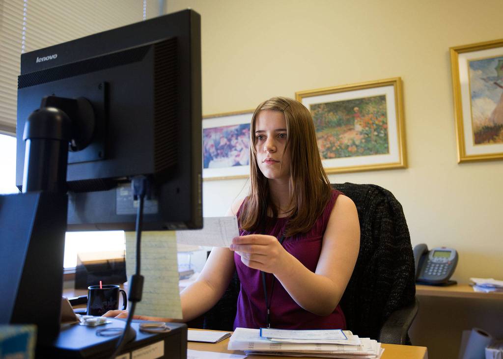 Alexandria Leslie processes donations for programs at Senior Services of Snohomish County on Dec. 5. Leslie started volunteering in June and now is on a temporary full time duty. (Andy Bronson / The Herald)