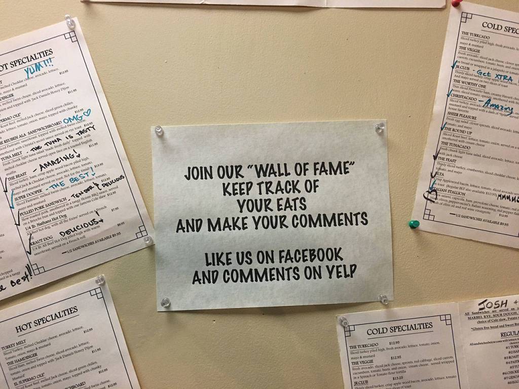 The wall near the front door is adorned with menus marked with happy customers reviews of the items. (Ben Watanabe / The Herald)