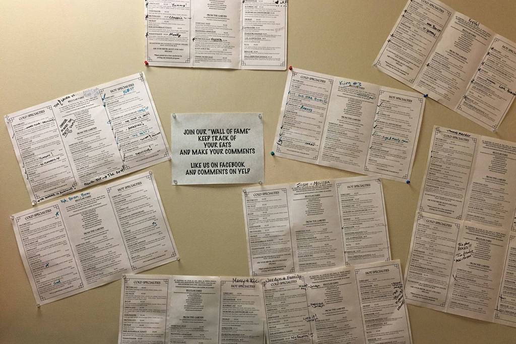The wall near the front door is adorned with menus marked with happy customers reviews of the items. (Ben Watanabe / The Herald)