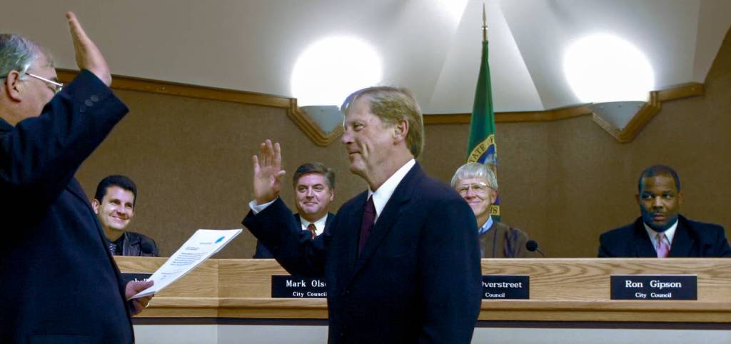 As City Council members watch in the background, Ray Stephanson is sworn in as mayor of Everett on Nov. 19, 2003, at the City Council Chambers by Municipal Court Judge Timothy ODell. The council members (from left) were Doug Campbell, Mark Olson, Bob Overstreet and Ron Gipson. (Herald file)