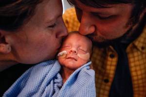 Elisabeth Strom and husband Steve Strom of Marysville kiss their son, Hugo, who was born on the way to the hospital Dec. 2, at 30 weeks. He weighed 3 pounds, 11.6 ounces. Hugo is in neonatal intensive care for several more weeks. (Dan Bates / The Herald)