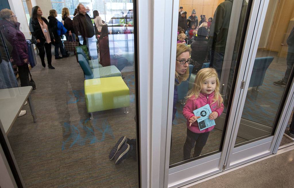 Upon arriving, Lacey Bogart and daughter Isla, 3, look toward the gym during an open house for students and parents at the new Lake Stevens Early Learning Center on Friday in Lake Stevens. (Andy Bronson / The Herald)