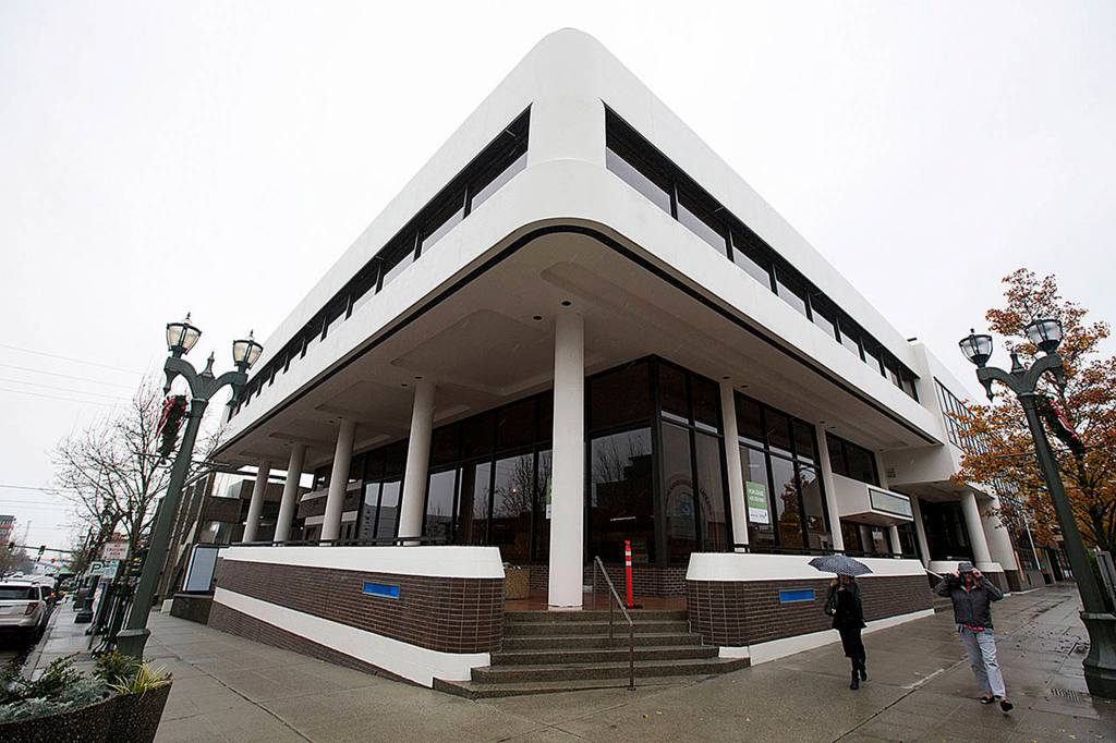 Pedestrians walk past the empty Opus bank building at the corner of Hewitt and Colby on Nov. 21 in Everett. (Andy Bronson / The Herald)